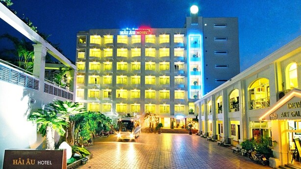 A hotel with a well-lit facade, a central courtyard, and a sign for the hotel. - Hai Au Hotel (Nha Trang)