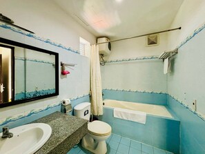 Een badkamer met een wastafel, toilet en bad.