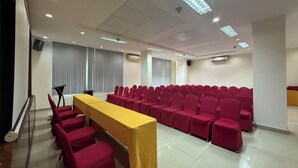 A conference room with a long table, rows of chairs, and ceiling lights. - Hai Au Hotel (Nha Trang)