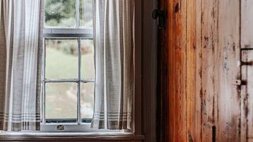 A room with a window, a wooden door, and a red bench.