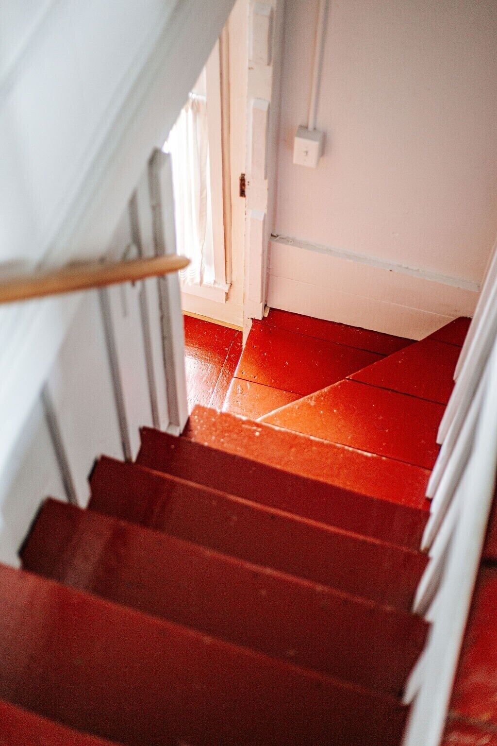 Un escalier avec des marches rouges menant à un palier.