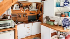 Coffee/tea maker, fridge, stovetop, cookware/dishes/utensils