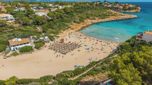 A coastal town with a sandy beach, villas, and a clear blue sea. - Cala Mendia Beach House 2 es with direct access to the beach and sea views (Portocristo - Cala Mandia)