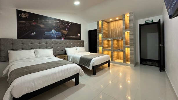 Une chambre d’hôtel avec deux lits, une grande affiche au mur et un mur décoratif en bois doté d’un éclairage intégré.