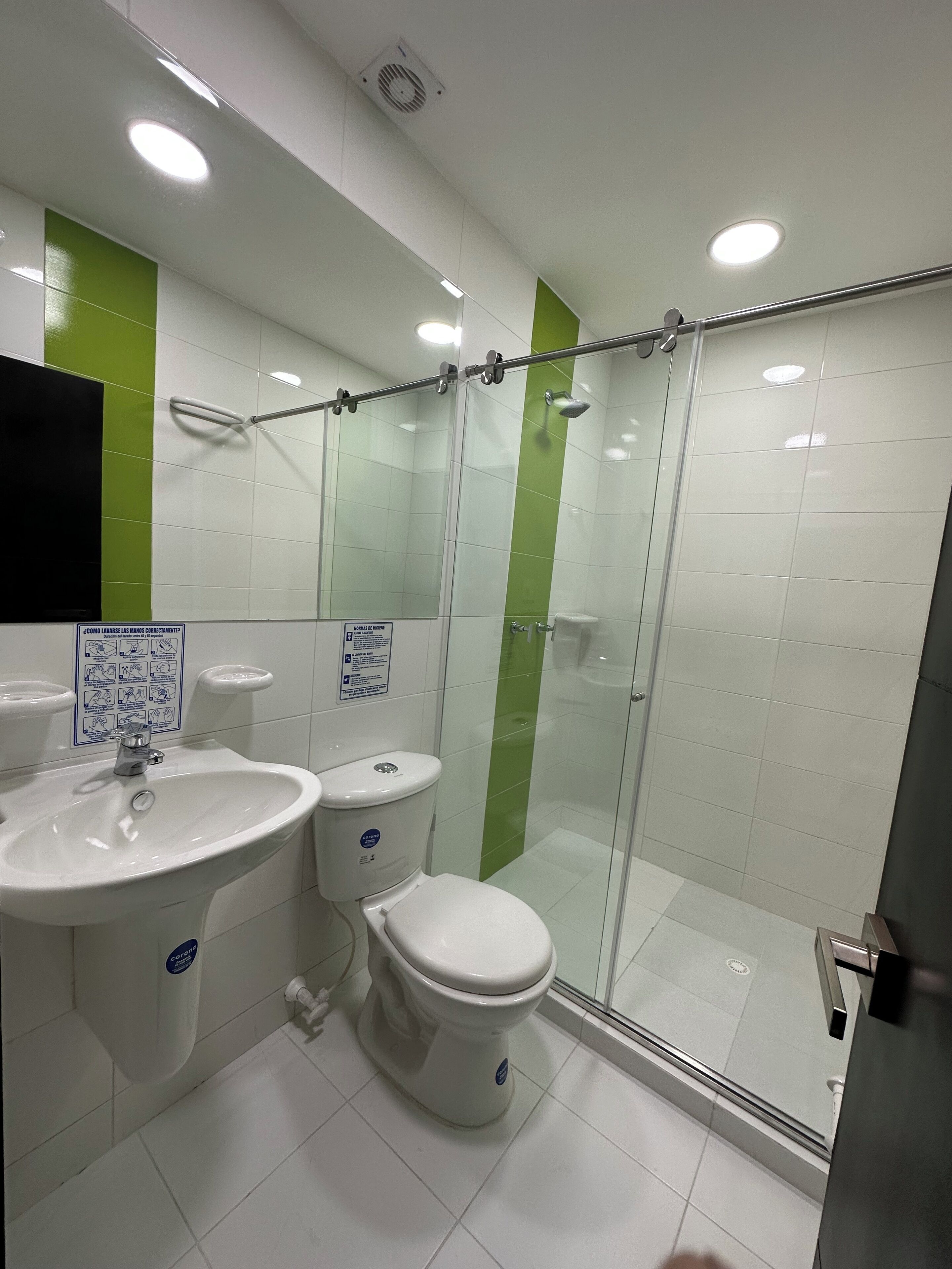 Une salle de bain équipée d’un lavabo, de toilettes et d’une douche à parois en verre.