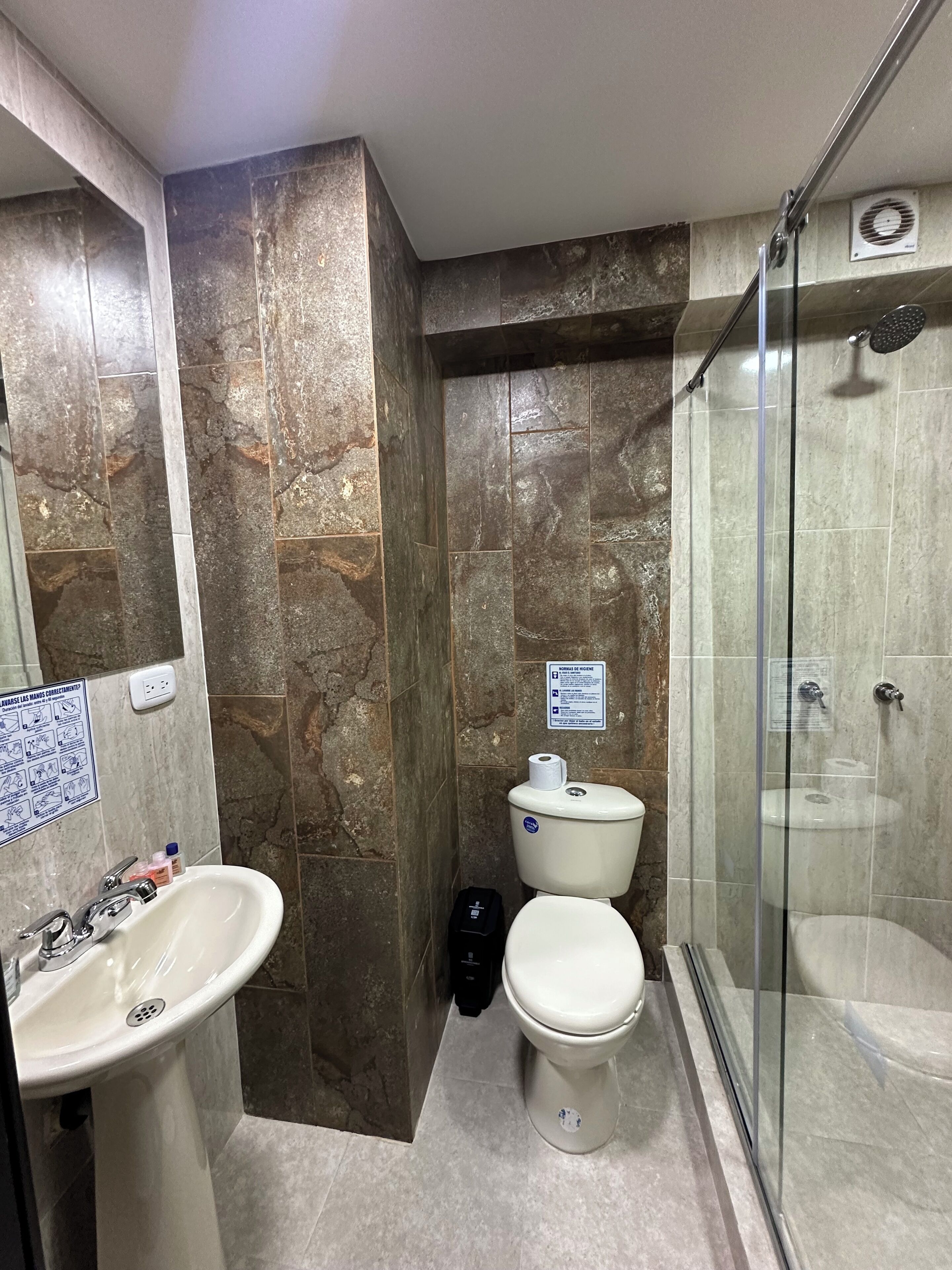 Un bagno con lavandino, water e cabina doccia in vetro.