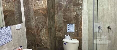 Un bagno con lavandino, water e cabina doccia in vetro.