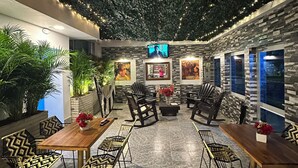 Un restaurant au décor moderne, avec un espace de restauration central comprenant des tables et des chaises, entouré de murs à l’aspect pierre.