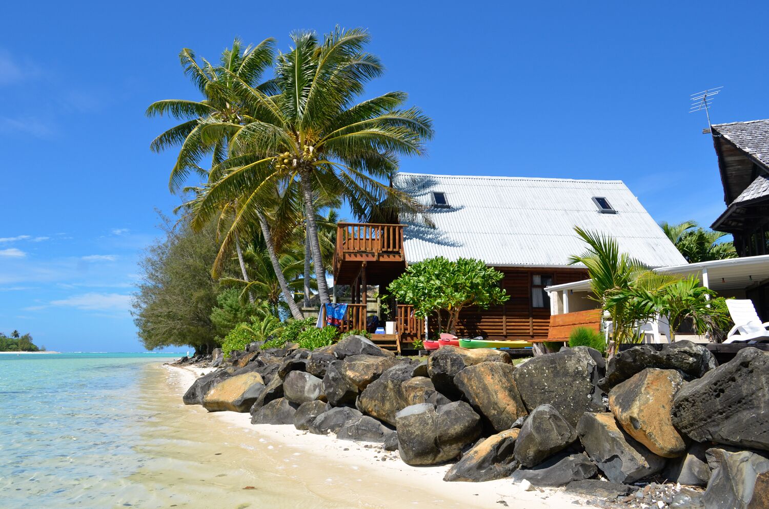 A beachfront property with a wooden deck, a balcony, and a view of the ocean.