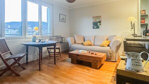 Ein Wohnzimmer mit einer Couch, einem Couchtisch und einem Esstisch.