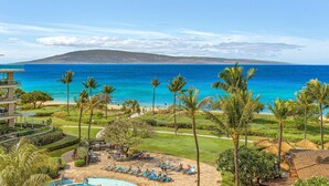 Un resort con piscina, sillas de descanso y vistas al océano.