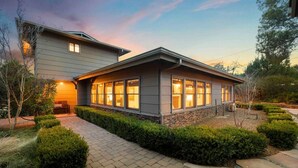Une maison moderne à deux étages, dotée d’un patio couvert et d’un jardin aménagé.
