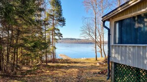 Una cabaña con vista a un lago y un bosque.