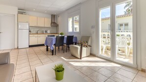 Una cocina moderna con comedor, un refrigerador blanco, un microondas y una mesa con sillas.