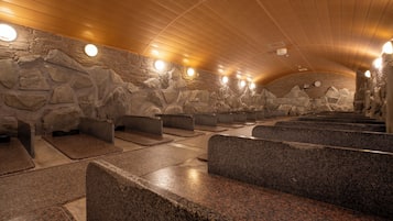 A sauna with stone walls and benches.