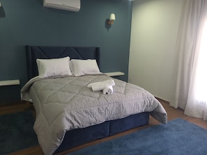 A neatly made bed with a quilt, pillows, and a rolled towel. - Villa Adam Tangier (Tangier)