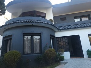 Un bâtiment moderne doté d’une façade incurvée, de grandes fenêtres et d’un petit balcon.