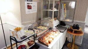 A buffet setup with various food items and a small table with binoculars.