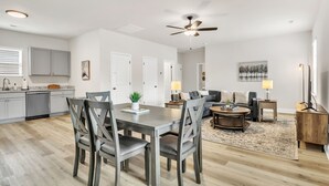 A modern apartment with a dining area, kitchen, and living room. - Pet-Friendly 2BR Greer Home, King Beds & Fire Pit (Greer)