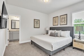 A bedroom with a bed, a nightstand, a lamp, a dresser, a mirror, and framed botanical prints on the wall. - Pet-Friendly 2BR Greer Home, King Beds & Fire Pit (Greer)