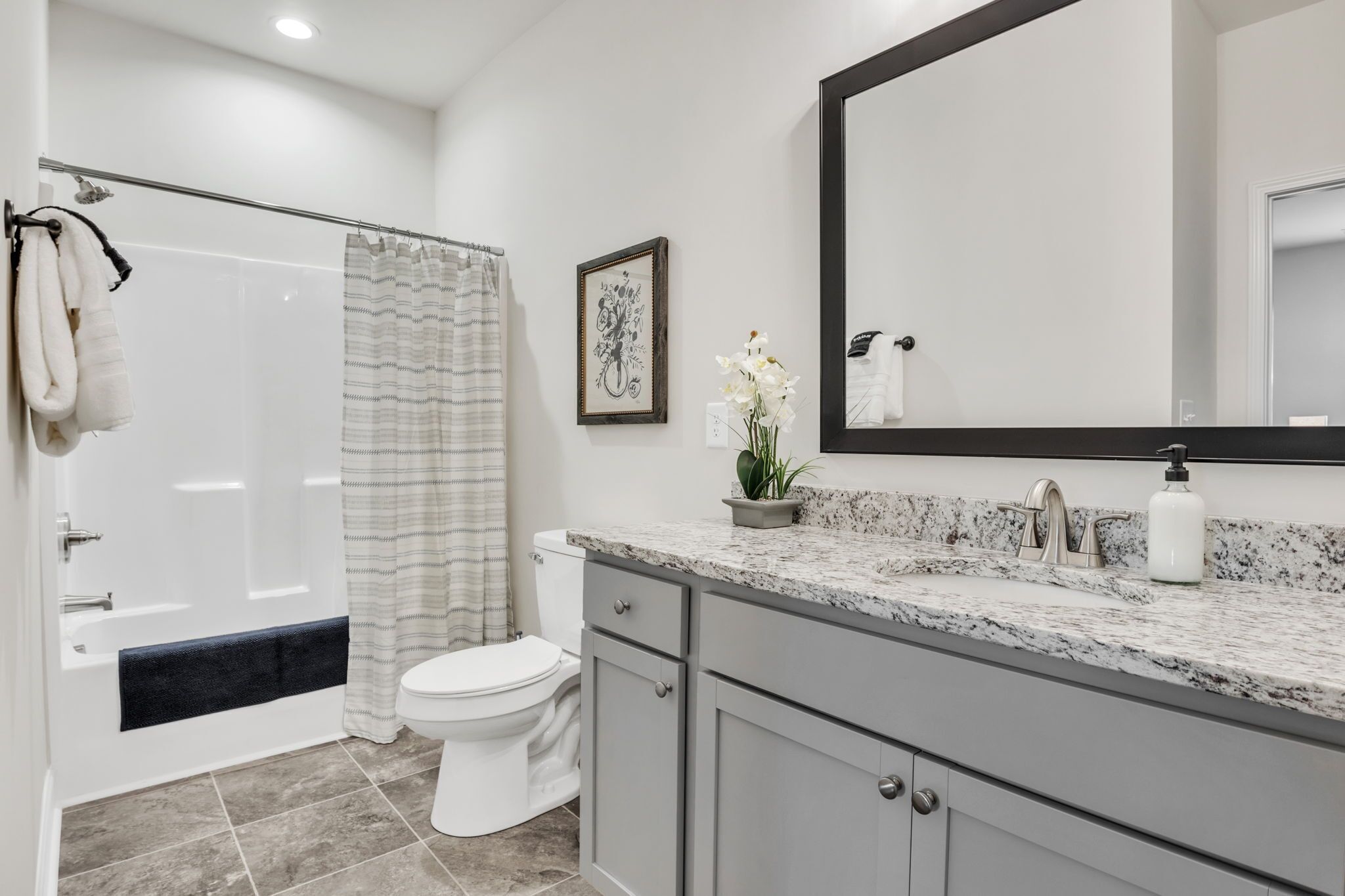 Une salle de bain moderne équipée d’une douche, de toilettes et d’un meuble-lavabo.