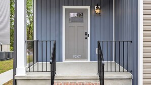 A house with a grey door, number 103A, and a small porch with black railings. - Family & Pets Welcome: 2BR in DT Greer w/ Fire Pit (Greer)