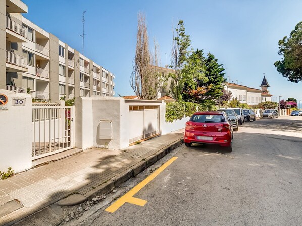 Une rue résidentielle où une voiture rouge est garée sur le bord.