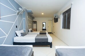 Een hotelkamer met twee bedden, een spiegel, een televisie en een raam.