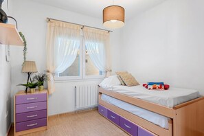 A child's bedroom with a bunk bed, a dresser, a lamp, and a window with curtains. - Villa Gran Sol 13 - PlusHolidays (Calpe)
