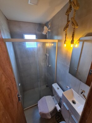 Une salle de bain moderne dotée d’une douche à parois de verre, de deux lavabos et d’un grand miroir.