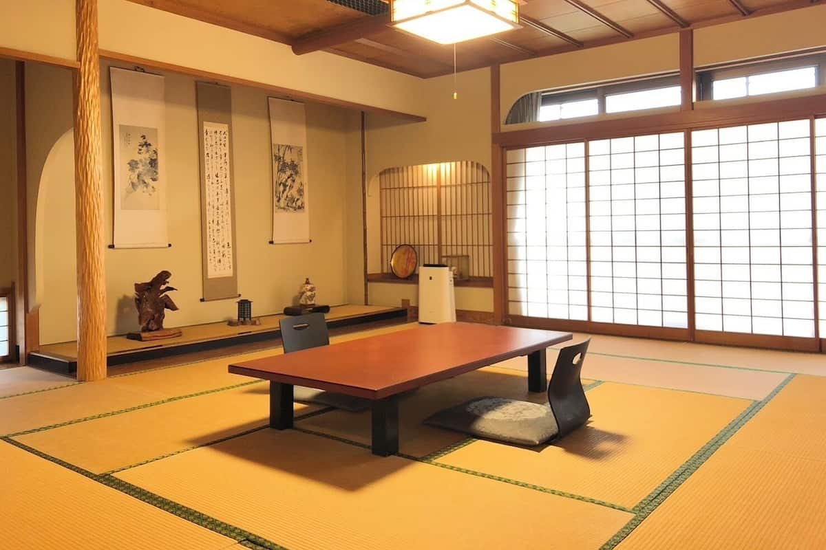 Um quarto japonês tradicional com tatame, uma mesa baixa e painéis shoji.