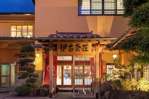 Un bâtiment japonais traditionnel, avec une entrée en bois et une enseigne portant des caractères japonais.