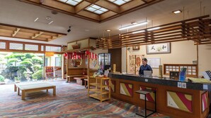 A reception area with a wooden desk, a bench, and a patterned carpet.