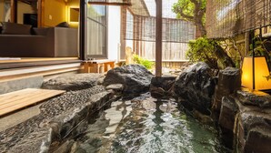 A traditional Japanese-style interior with a koi pond, wooden flooring, and a seating area.