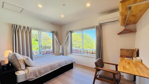 A bedroom with a bed, a desk, and two windows with curtains. - Beach side Pension mibal (Nanjo)