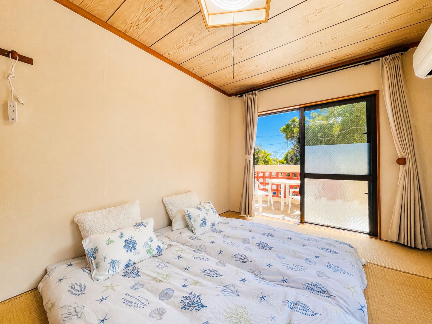 A bedroom with a bed, a window, and a view of the outside.