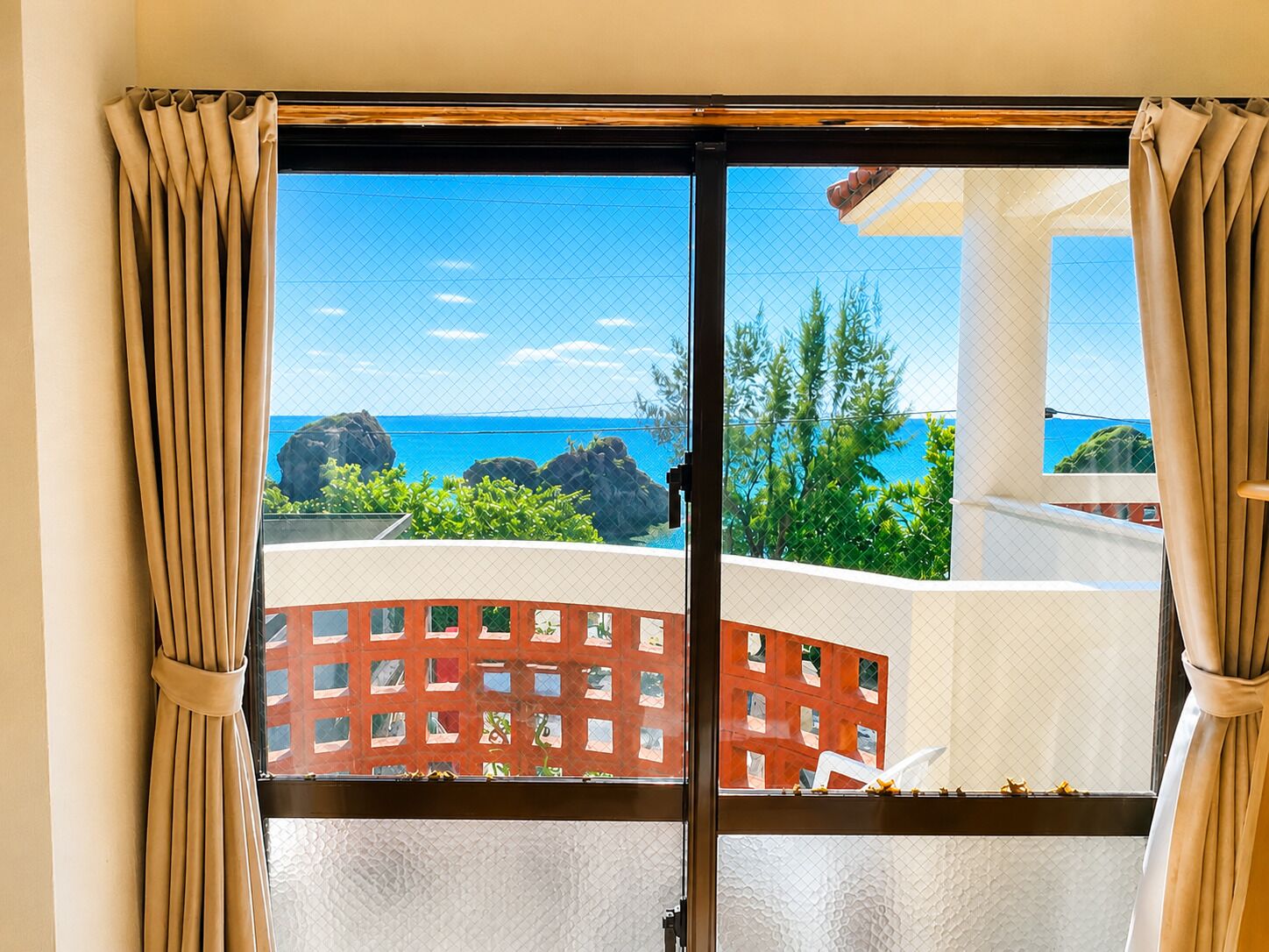 A room with a view of the ocean and rocky outcrops.