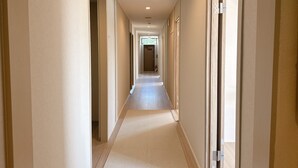 A long, narrow hotel corridor with doors on both sides, leading to individual rooms. - Beach side Pension mibal (Nanjo)
