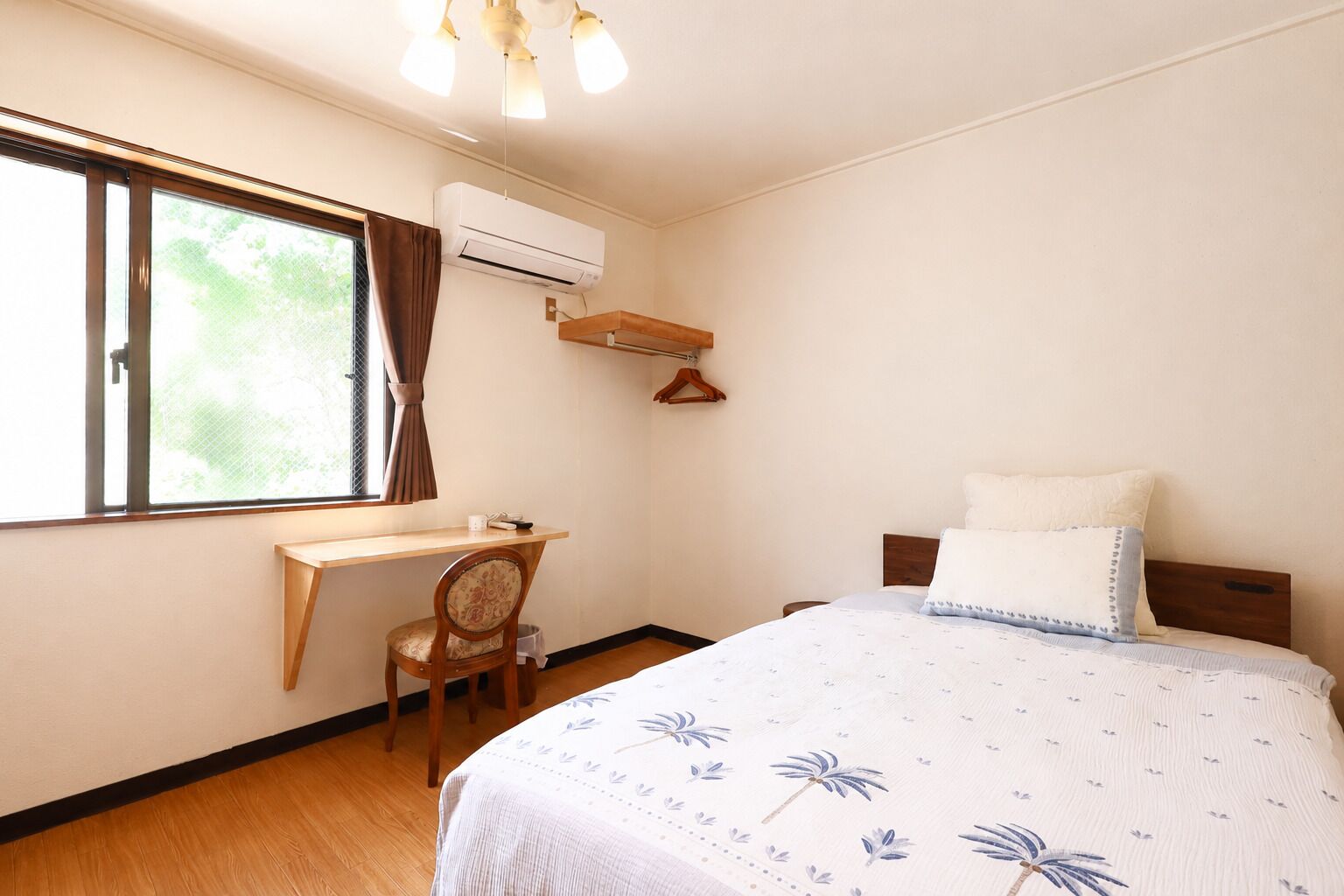 Un dormitorio con cama, escritorio y aire acondicionado.