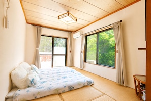 Un dormitorio con cama, ventana y una lámpara en el techo.