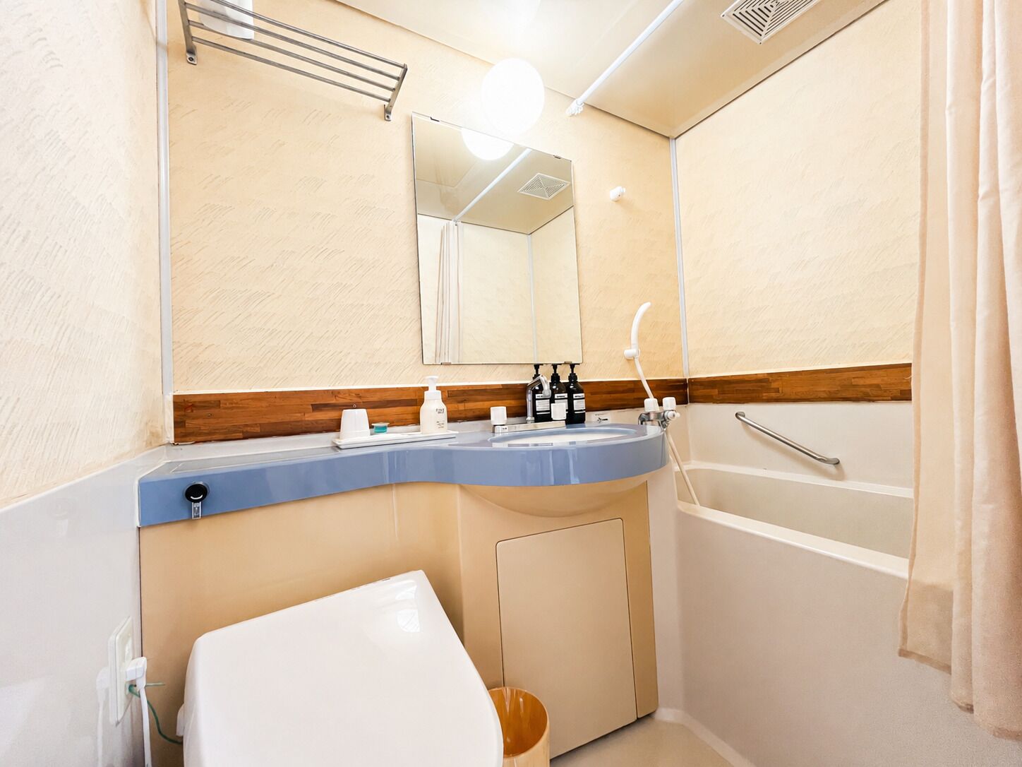 A bathroom with a sink, mirror, and shower.