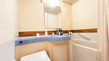 A bathroom with a sink, mirror, and shower.