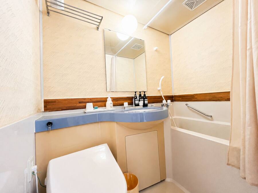 A bathroom with a sink, mirror, and shower.