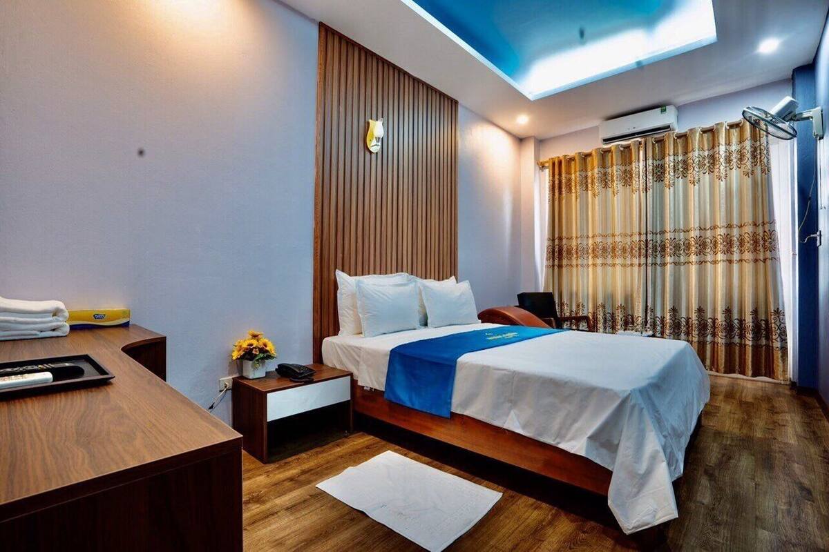 Ein modernes Hotelzimmer mit einem hölzernen Bett, einem Schreibtisch und einem Oberlicht.