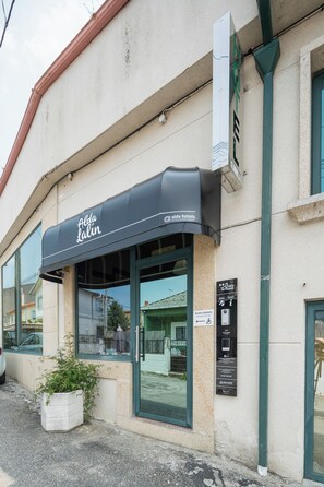 A hotel with a black awning, large windows, and a sign indicating accessibility features. - Alda Lalín (Lalin)