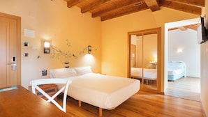 A bedroom with a wooden ceiling, a bed, a chair, and a small table. - Alda Lalín (Lalin)