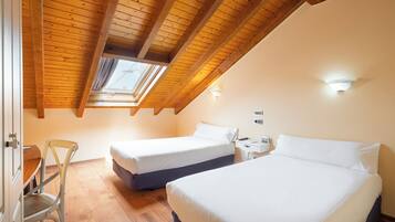 A bedroom with two beds, a wooden ceiling, and a skylight.