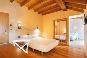 Un dormitorio con techo de madera, una cama, una silla y una mesita.