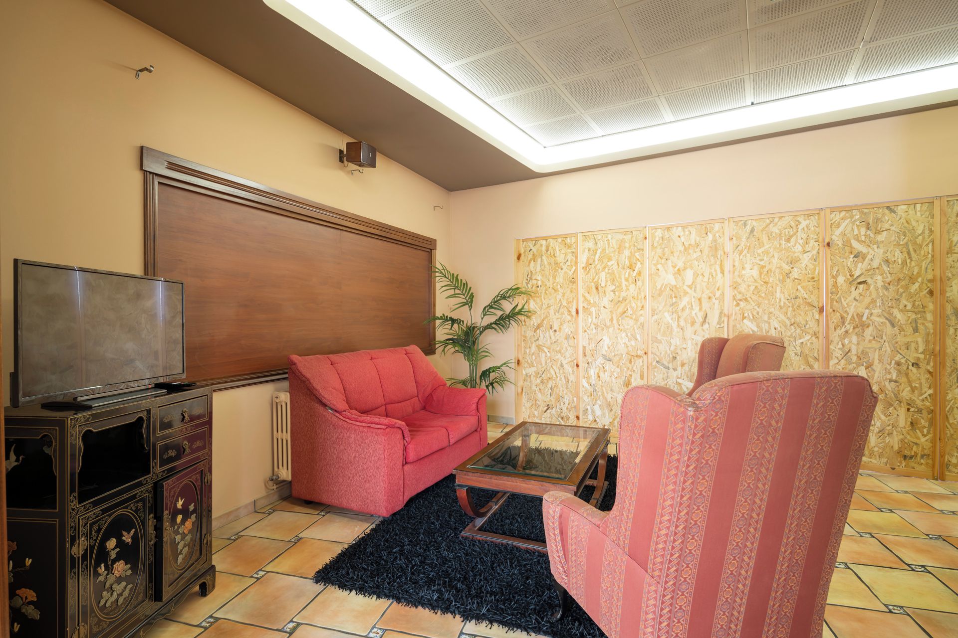 A living room with a television, two sofas, a coffee table, and a radiator.