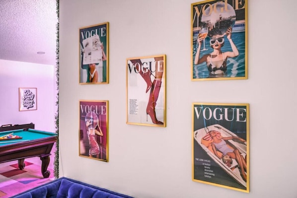 A room with a pool table, a blue sofa, and four framed magazine covers on the wall. - 70s Villa! Heated Pool+Spa, Basketball, Pickleball - Holiday Home (Las Vegas)